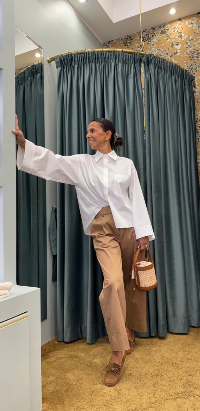 Camicia bianca e pantalone beige in boutique